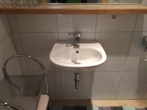 a white sink in a bathroom with a mirror at Pension Wieser "Baschtlmai" in Altenmarkt im Pongau