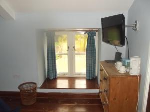 a room with a window and a television on a dresser at Pleck Barn B&B in Ansty
