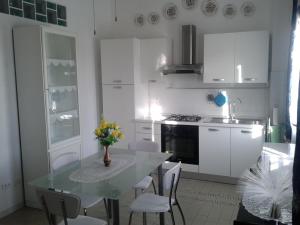 a kitchen with a glass table and white cabinets at Park Hotel in Molinella