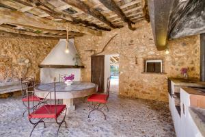 
a kitchen with a table, chairs and a fireplace at Agroturisme Son Pons in Búger
