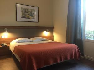 a bedroom with a bed with a red blanket and a window at Chambres Rue de la République in Collioure