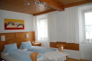 DonnersbachにあるGasthof Rüscherのベッドルーム1室(ベッド2台、テーブル、窓付)