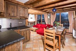 een keuken en een woonkamer met een rode bank bij Parc du Mont Blanc 12 appt - Chamonix All Year in Chamonix-Mont-Blanc