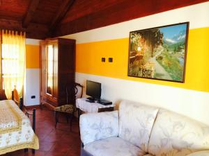 sala de estar con sofá y TV en la pared en Ca di Voi en Calizzano