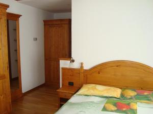una camera con letto e testata in legno di Affittacamere La Falconetta a Champoluc