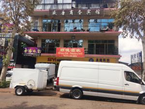 Una camioneta blanca estacionada frente a un edificio en Shengtang Business Hotel, en Johannesburgo