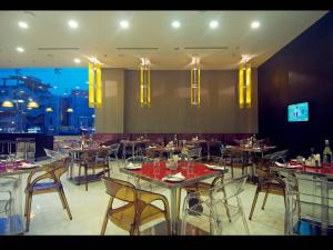 a restaurant with tables and chairs with a view at Keys Select by Lemon Tree Hotels, Visakhapatnam in Visakhapatnam