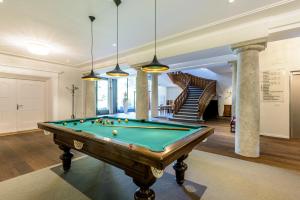 a pool table in a room with a staircase at Kurhotel Im Park in Schinznach Bad