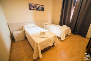 a room with two beds and two tables at Hotel Moderno in Lecco