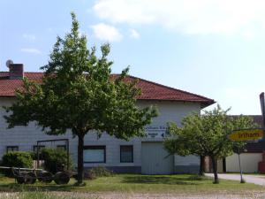 Gasthaus Hingerl في Obing: مبنى ابيض امامه شجرة