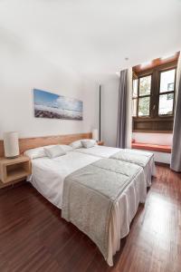 um quarto com uma grande cama branca e janelas em Anchieta 60 em San Cristóbal de La Laguna