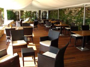 a restaurant with tables and chairs on a wooden deck at Relais Villa Margherita in Oggebbio