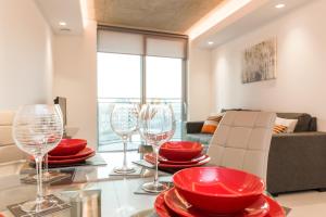 a living room with red plates and wine glasses on a table at Royal Style Apartment - 5 mins walk to ExCeL London in London