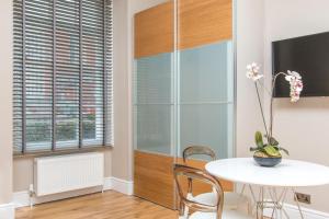 a dining room with a table and chairs and a tv at Number 1 Park Apartments in Bristol