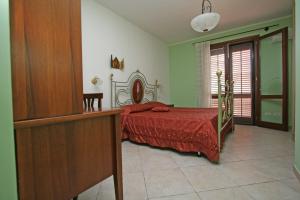 サン・ヴィート・ロ・カーポにあるAppartamento Armonie Verdeのベッドルーム1室(赤い掛け布団付きのベッド1台付)