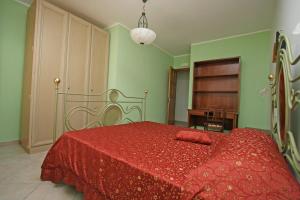 サン・ヴィート・ロ・カーポにあるAppartamento Armonie Verdeの赤いベッド1台(赤い毛布付)が備わるベッドルーム1室が備わります。