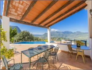 エル・ガストルにあるHoliday home in El Gastor 100823の山々の景色を望むパティオ(テーブル、椅子付)