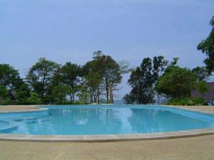 a blue swimming pool with trees in the background at Kohchang Privilege in Ko Chang