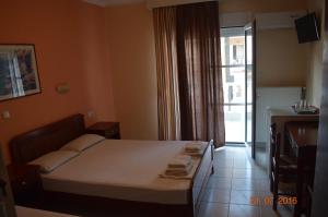 a small bedroom with a bed and a window at Philippos Hotel in Paralia Katerinis