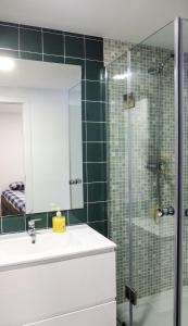 uma casa de banho com um lavatório e um chuveiro com um espelho. em Traditional Lisbon Madragoa Studio em Lisboa