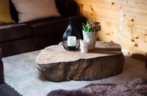 a tree stump coffee table with vases and flowers on it at Fleurs Des Prés in Les Villards-sur-Thônes +20 photos