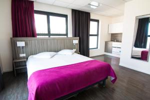 een slaapkamer met een groot bed en een paarse deken bij Tulip Inn Thionville Residences in Thionville