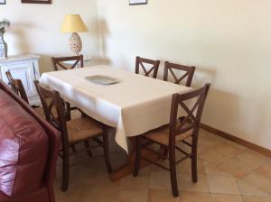 a dining room table and chairs with a white table cloth at Appartamenti Cavriè in Torri del Benaco