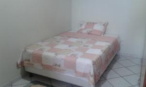 a small bedroom with a pink and white bed at Apto Arpoador Próximo Praia VV in Vila Velha