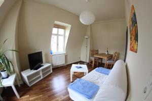 a living room with a bed and a tv at Dampfschiff Radebeul-Altkö in Radebeul