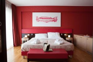 1 dormitorio rojo con 1 cama grande con pared roja en Klass Hotel, en Castelfidardo