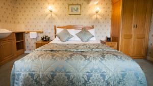 a bedroom with a blue and white bed with a sink at Aynsome Manor Hotel in Cartmel