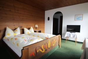 a bedroom with a bed and a television in it at Pension Christoph in Kramsach