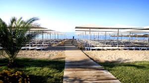 una spiaggia sabbiosa con tavoli, ombrelloni e sedie di Riolavitas Resort & Spa a Side