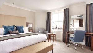 a hotel room with a bed and a desk at Thistle London Piccadilly in London