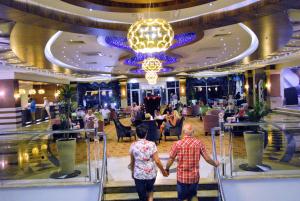 twee mensen lopen de trap af in een restaurant bij Dizalya Palm Garden Hotel in Konaklı