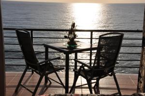 uma mesa e duas cadeiras numa varanda com o oceano em Studio Vue Mer em Torremolinos
