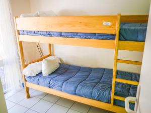 - une chambre avec 2 lits superposés et des draps bleus dans l'établissement Village Vacances Les Genêts, à Léon