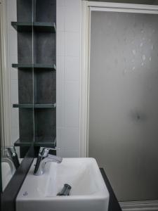 a bathroom with a white sink and a shelf at Village Vacances Les Genêts in Léon +17 photos