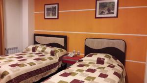 two beds sitting next to each other in a room at Apart Serma Hotel in Potosí