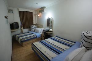 una camera d'albergo con due letti e una televisione di Yi Yuan Hotel a Taipei