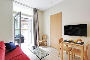 a living room with a red couch and a table at Milestay Opera Lafayette - Serviced Apartment in Paris