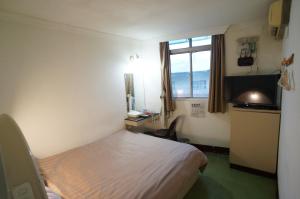 - une petite chambre avec un lit et une fenêtre dans l'établissement Yi Yuan Hotel, à Taipei