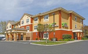 um grande edifício laranja com estacionamento em Extended Stay America Suites - San Jose - Edenvale - North em San José