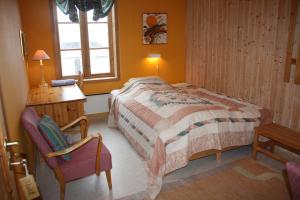 Schlafzimmer mit einem Bett, einem Schreibtisch und einem Stuhl in der Unterkunft Gunnabuda in Longva