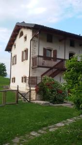 uma grande casa branca com varanda e flores em Casa Giovannella em Feltre