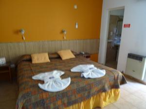 Una habitación de hotel con una cama con toallas. en De a Dos en San Rafael
