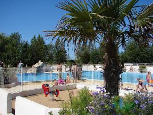 a swimming pool with people in a resort at Camping Phare Ouest in Saint-Denis-dʼOléron