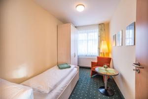 a small room with a bed and a table at Am Weststrand Apartmenthaus Bellamare in Kühlungsborn +121 photos
