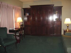 a living room with a couch and a table and a cabinet at Lockport Inn and Suites in Lockport