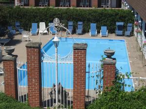 a swimming pool with a gate and chairs at Lockport Inn and Suites in Lockport